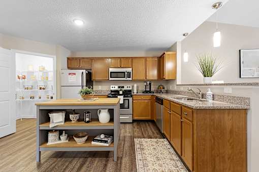 A kitchen with wooden cabinets and a grey island.