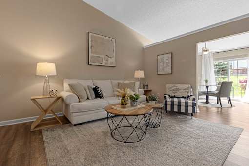 A living room with a white sofa, a coffee table, and a chair.