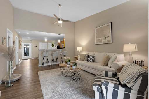 A living room with a sofa, a table, and a ceiling fan.