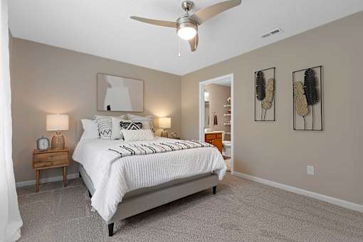 A bedroom with a large bed and a ceiling fan.
