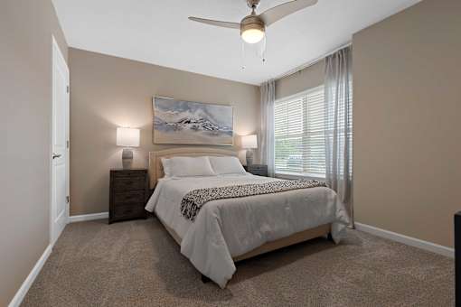 A bedroom with a bed, nightstands, and a painting on the wall.