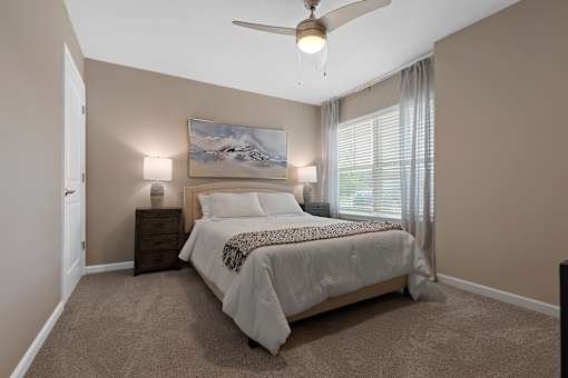 A bedroom with a large bed and a painting on the wall.