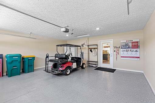 A room with a golf cart and a door with a sign on it.