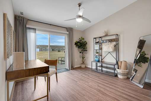 A room with a wooden table and a fan.