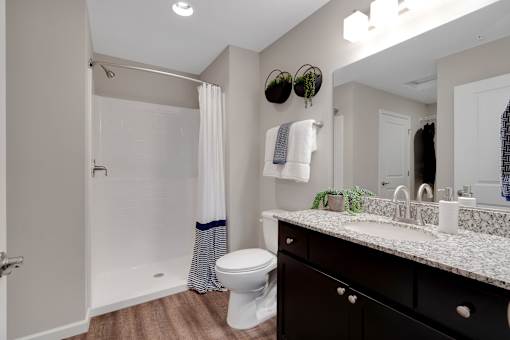 A bathroom with a toilet, sink, and shower.