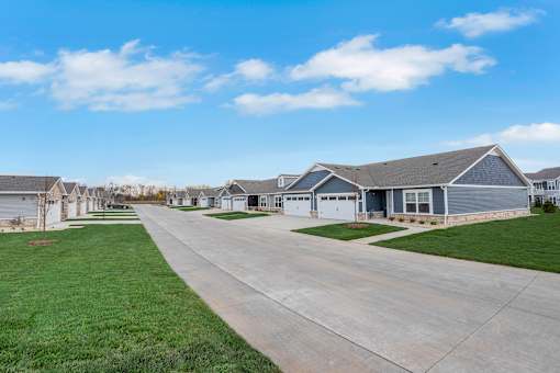 A row of houses with a driveway in the foreground.