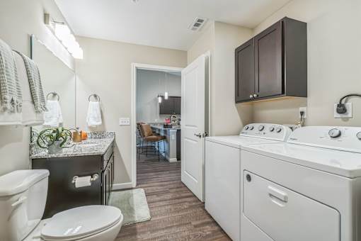 A small bathroom with a toilet, sink, and mirror.