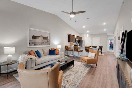 A living room with a grey couch, a coffee table, and a ceiling fan.