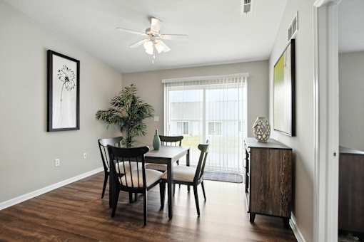 A dining room with a table and chairs.