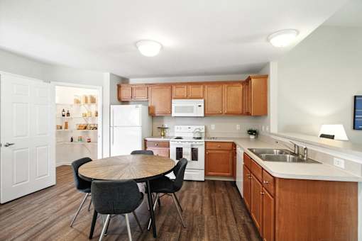 A kitchen with a table and chairs in the middle of the room.