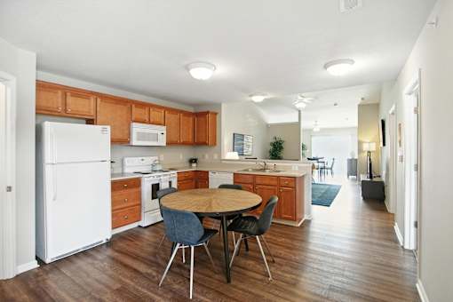 A kitchen with a white refrigerator and wooden cabinets.