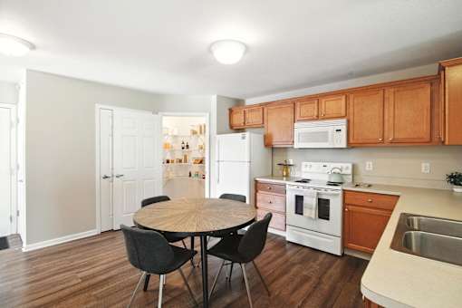 A kitchen with a table and chairs.