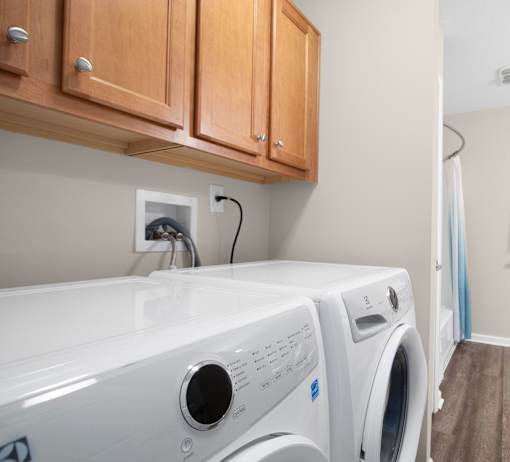 A white washing machine and dryer in a laundry room.