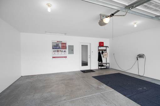 A white wall with a red sign and a black and white poster.