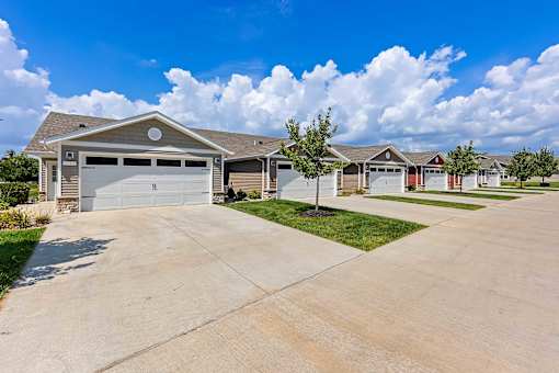 A house with a garage is surrounded by other similar houses.