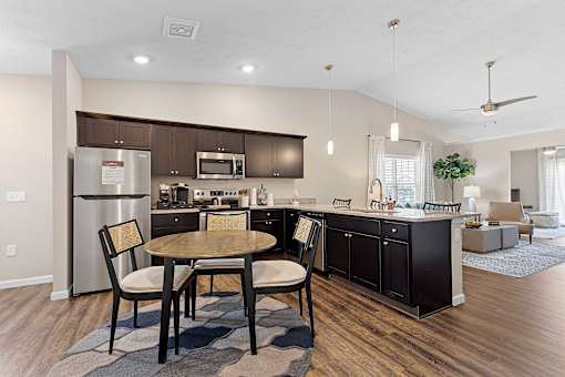 A modern kitchen with a dining table and chairs.