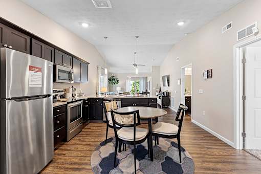 A kitchen with a table and chairs in the middle of the room.