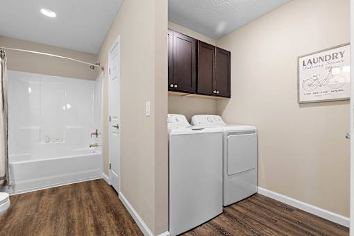 A laundry sign is on the wall above a washer and dryer.