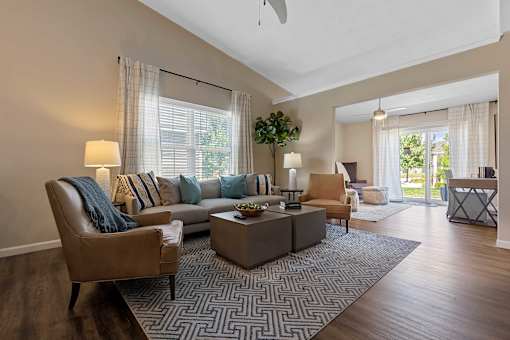 A living room with a brown leather chair and a grey sofa with blue and white pillows.