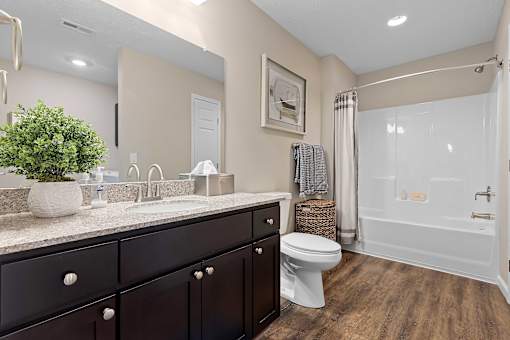 A bathroom with a white toilet and a white bathtub.