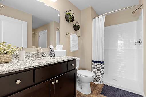 A bathroom with a toilet, sink, and shower.