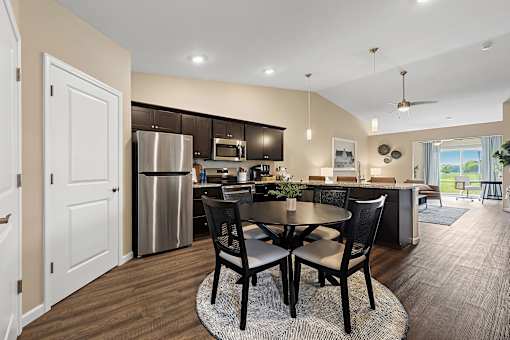 A modern kitchen with a dining table and chairs.