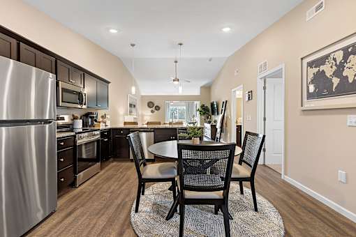 A kitchen with a table and chairs in the middle of the room.