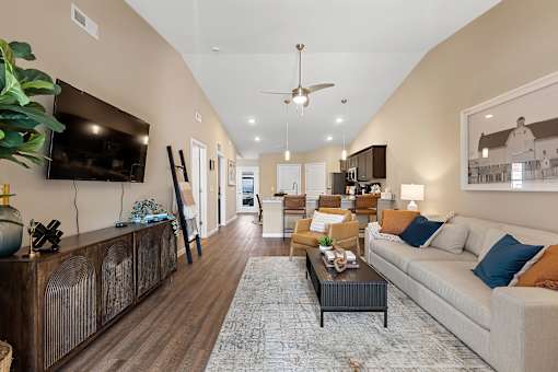 A living room with a white couch and a wooden coffee table.