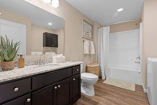 A bathroom with a white toilet and a white bathtub.