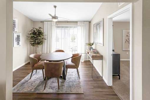 A dining room with a round table and chairs.