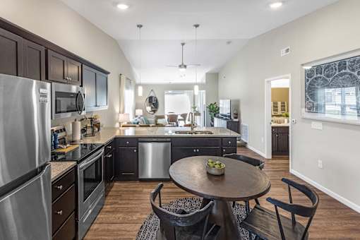 A modern kitchen with dark wood cabinets and stainless steel appliances.