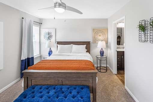 A bedroom with a bed, a ceiling fan, and a rug.