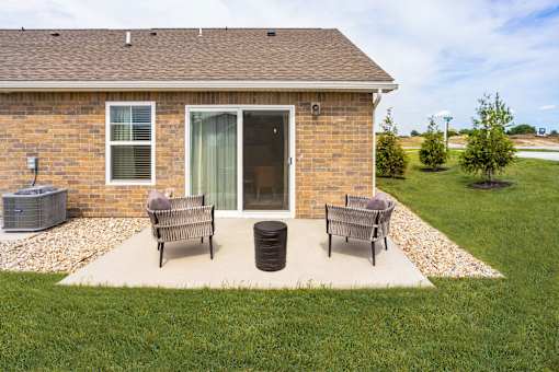 A house with a patio and a trash can.