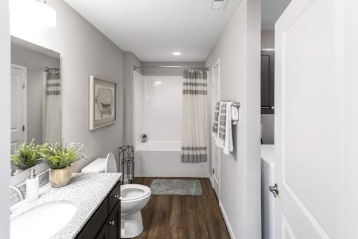 A white bathroom with a toilet, sink, and bathtub.