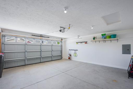 A garage with a grey door and a white wall.