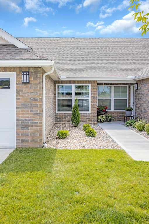 A house with a white garage door and a small garden in front.