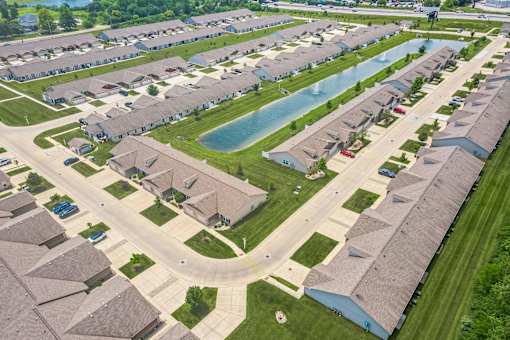 A bird's eye view of a residential neighborhood with houses and a swimming pool.