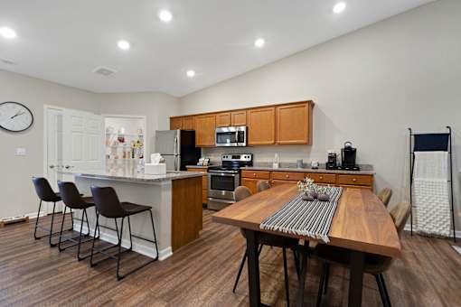 A kitchen with a table and chairs in the middle of the room.
