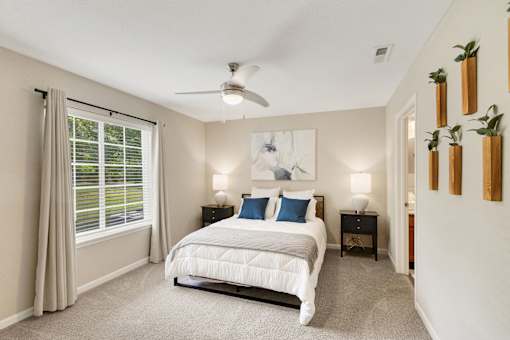 A bedroom with a large bed and a ceiling fan.