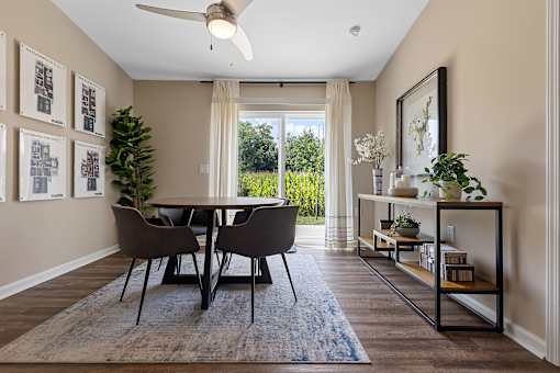 A dining room with a table and chairs.