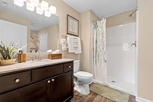 A bathroom with a toilet, sink, and shower.