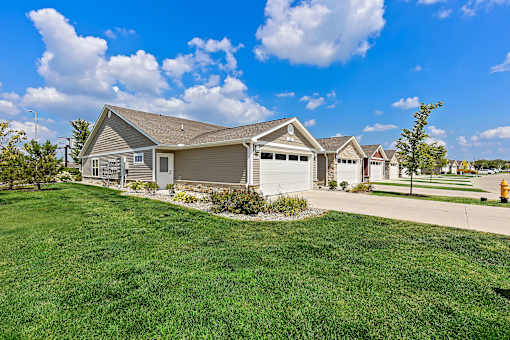 A house with a garage and a driveway in front of it.