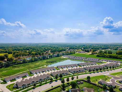 A bird's eye view of a residential area with houses and a lake.