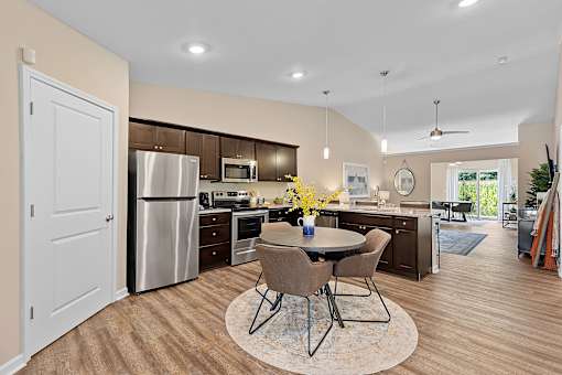 A kitchen with a table and chairs in the middle of the room.