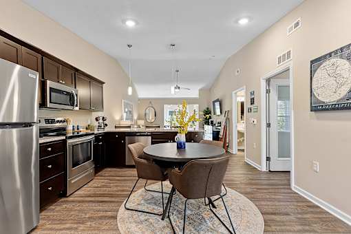A kitchen with a table and chairs in the middle of the room.