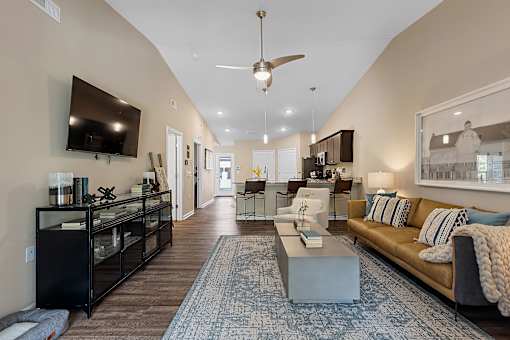 A living room with a couch, a coffee table, and a television.