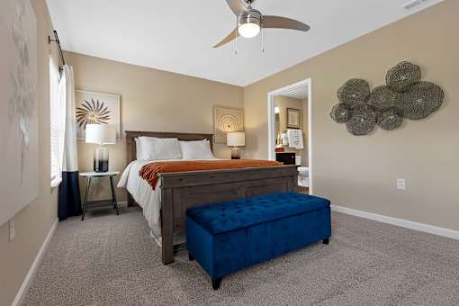 A bedroom with a bed, nightstand, and a ceiling fan.