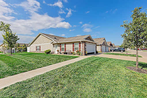 A house with a green lawn in front of it.