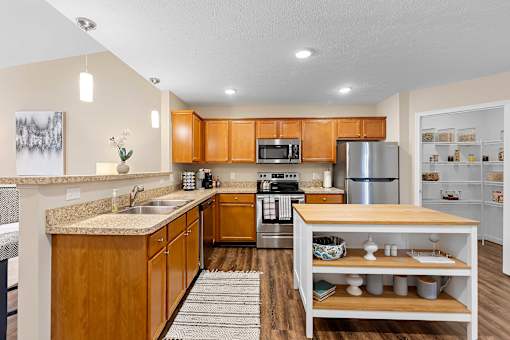 A kitchen with wooden cabinets and a stainless steel refrigerator.