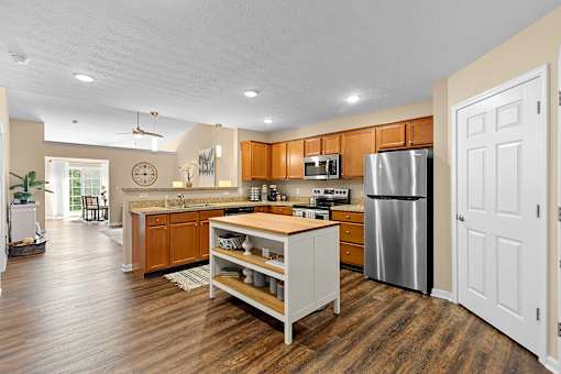 A kitchen with wooden floors and a white island.